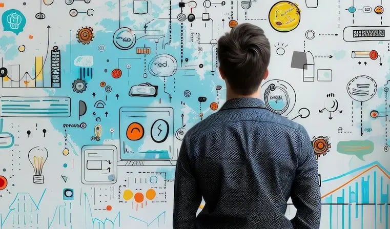 Brand manager staying in front of a wall full of icons, processes and pictures relating to brand management