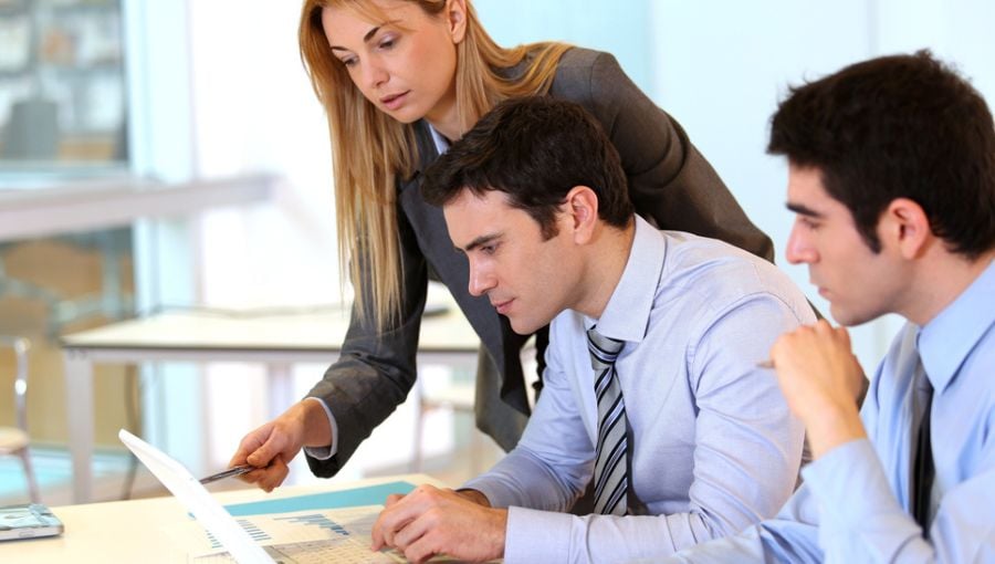 Businessteam of young adults working together on project by the desk