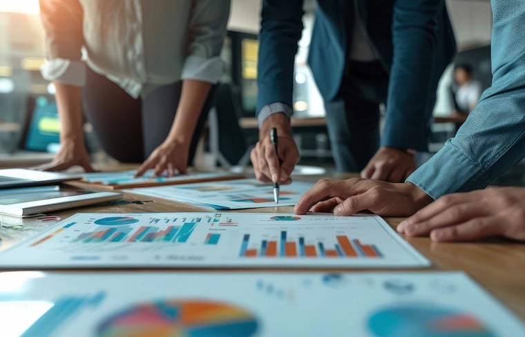 Charts and sheets on the desk with marketing operations team planning strategy
