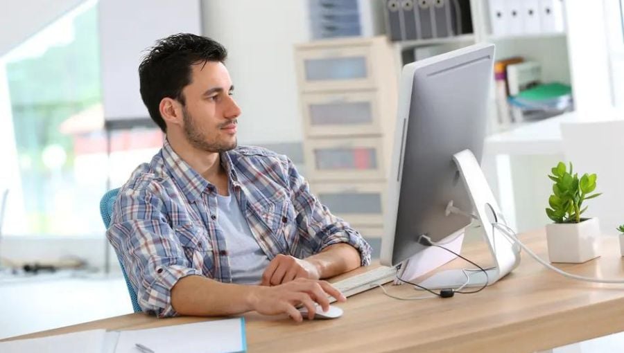 Web designer working on a creative process and collaborates with team by his desktop computer 
