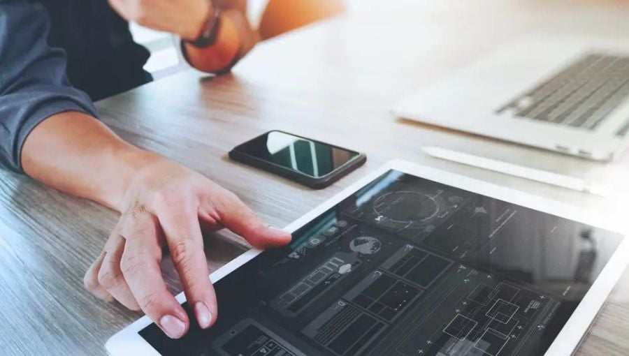 20 best web design tools for creative teams: Designer working on a creative project with his design tools on a tablet