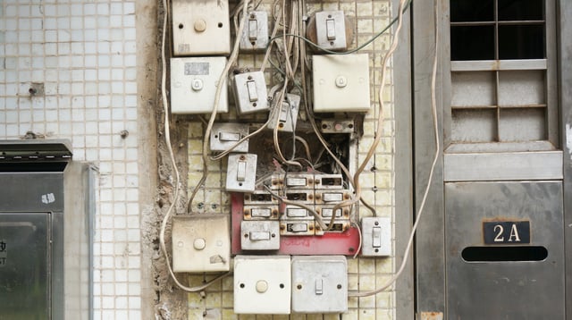 Wires and cables non-organised loosely on a wall with contacts