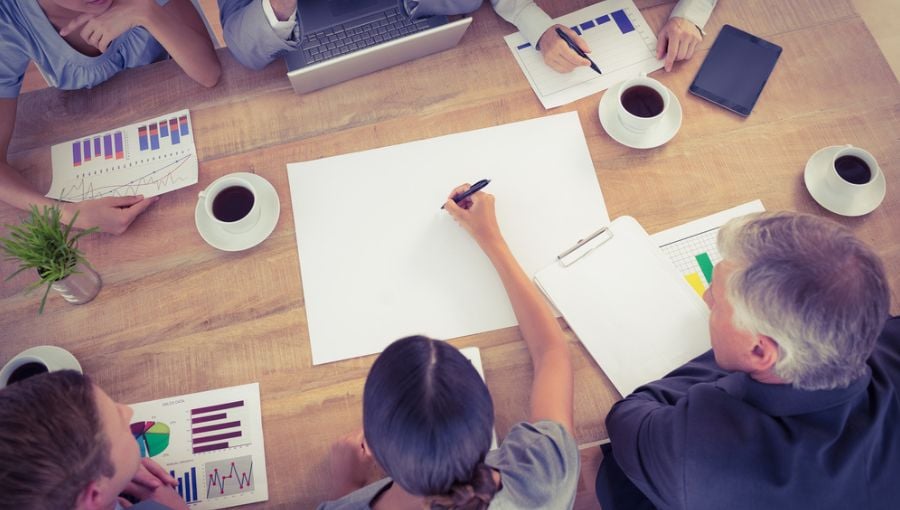 Marketing leader analyzes creative metrics with his teams by the desk