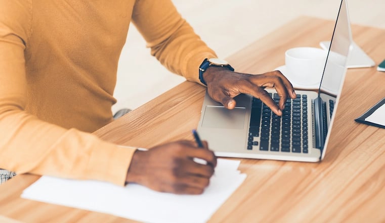 Marketing manager using both paper and a laptop for creative briefing