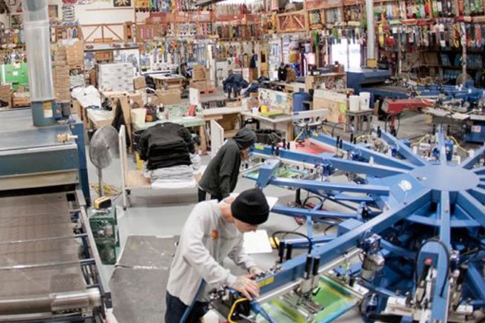 NHS skateboard factory indoors with employees working on boards asembly