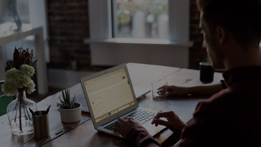Creative marketer working remotely with a team by his laptop and desk from home