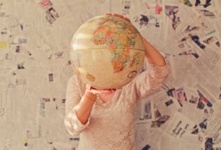 Man holding a globe in front of his face to show international company character