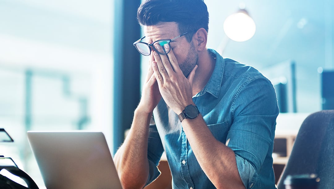 Marketing designer rubbing his eyes with fatigue